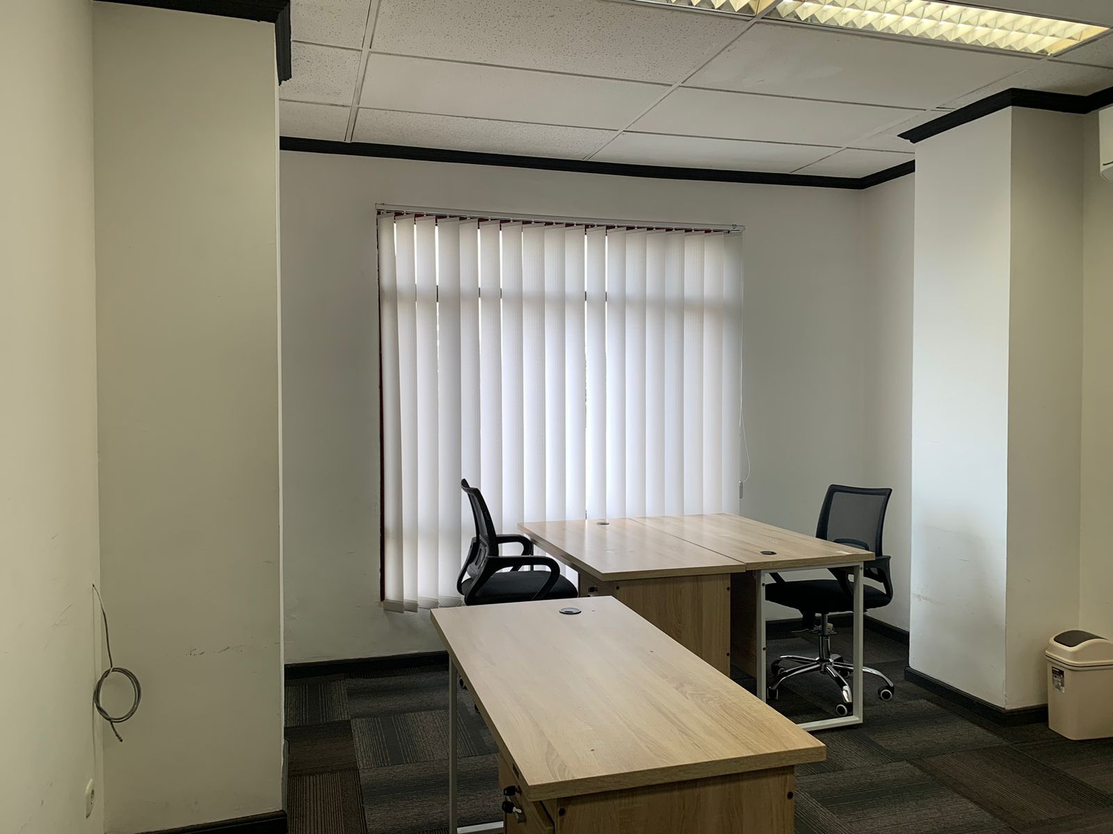 Ruang kantor dengan tiga meja kerja di dekat jendela
